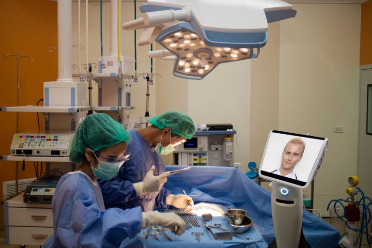 Photo of a remote surgeon communicating with a team in an operating theatre via a connected device