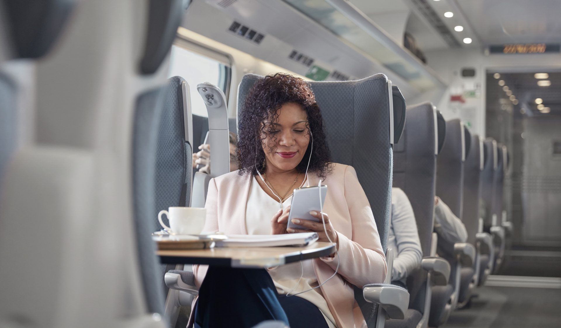 photo of a businesswoman using a smartphone on a passenger train