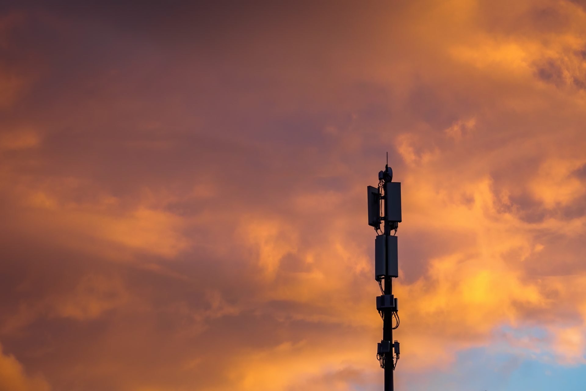 Mobile phone mast against dramatic sunset clouds