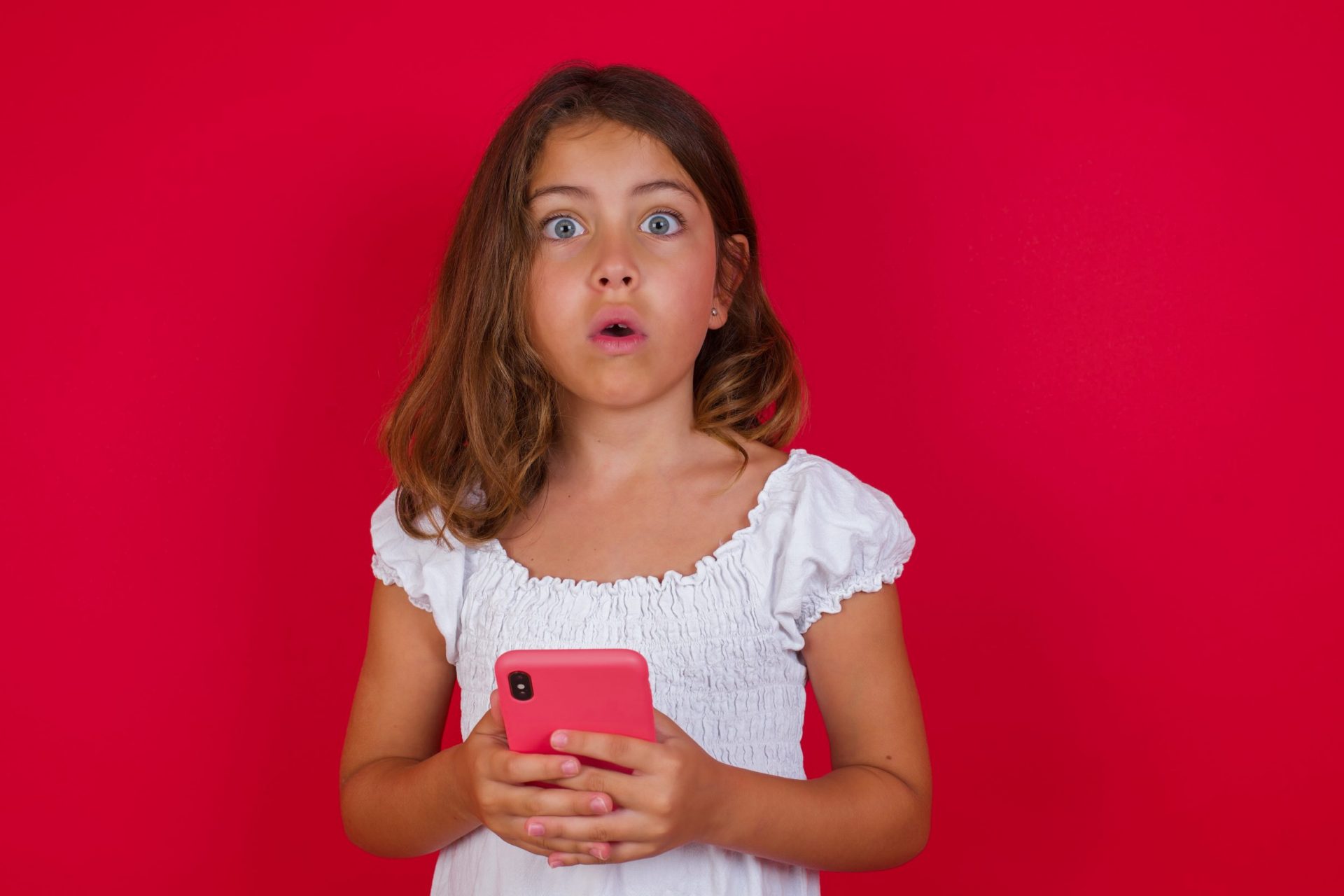 Young girl surprised by what she's seen on her smartphone