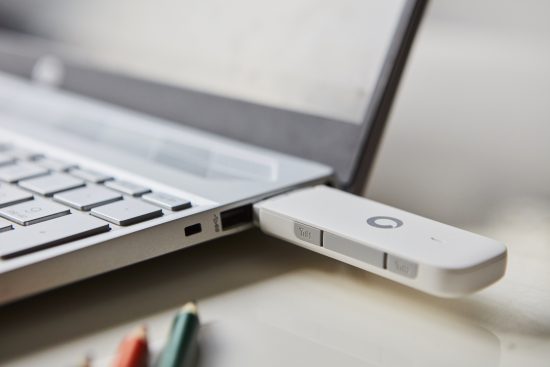 close-up photo of a Vodafone 4G USB dongle inserted into a Windows laptop.