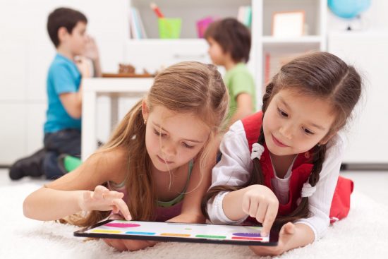 Back to school: Two little girls sharing a tablet computer