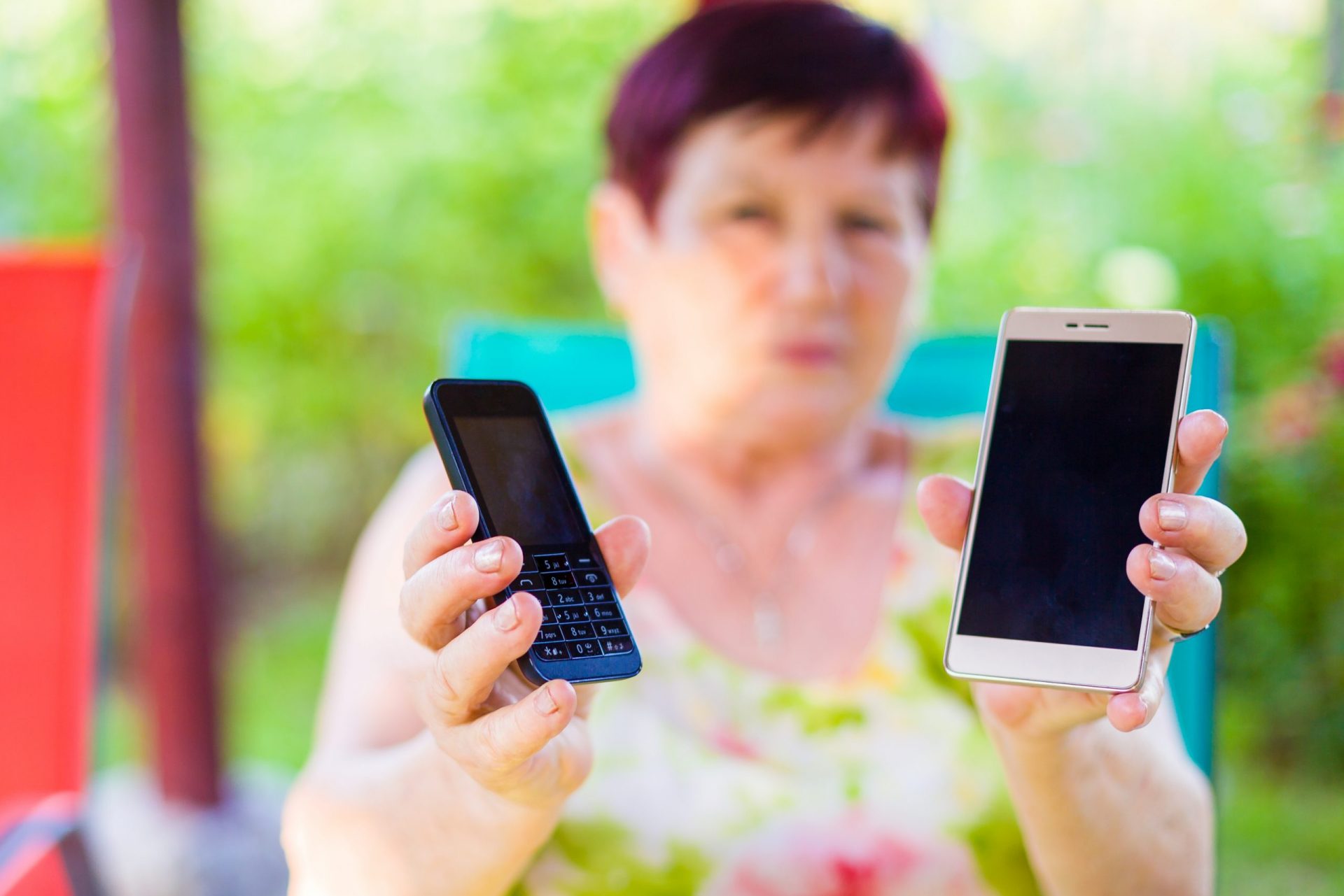 Older woman holding old and new mobile phones
