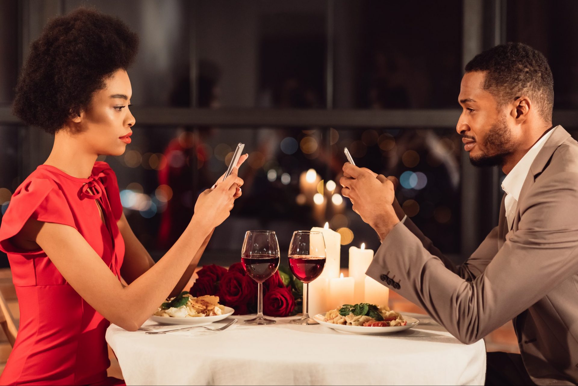 Couple at dinner in restaurant looking at their mobile phones