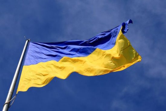 Ukraine flag blowing in the wind against a blue sky
