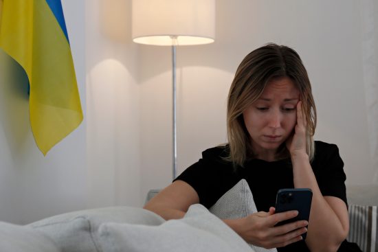 Young woman trying to find out news about Ukraine on her phone