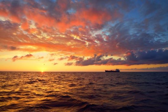 Merchant ship, open sea, sunset