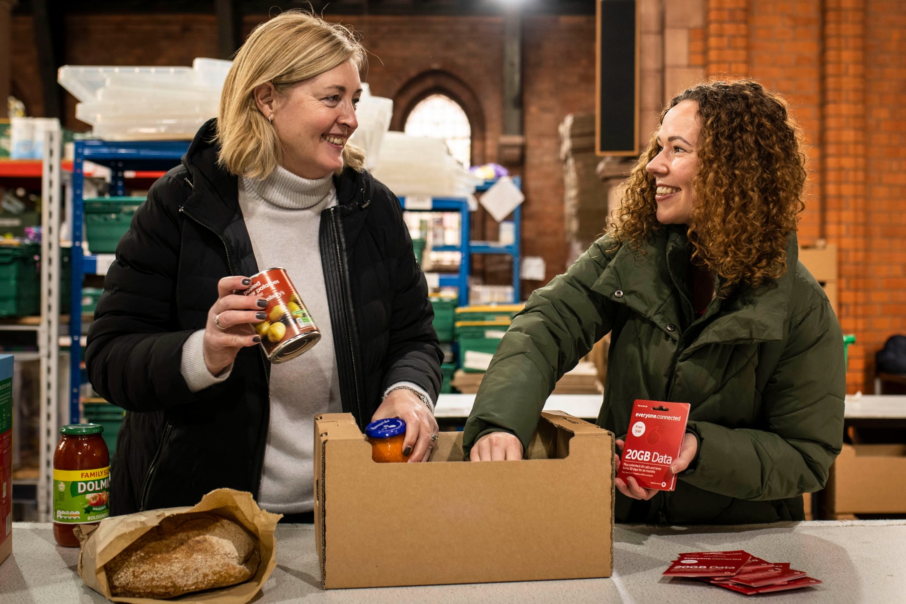 photo of The Trussell Trust's Emma Revie and a Vodafone volunteer at a London food bank