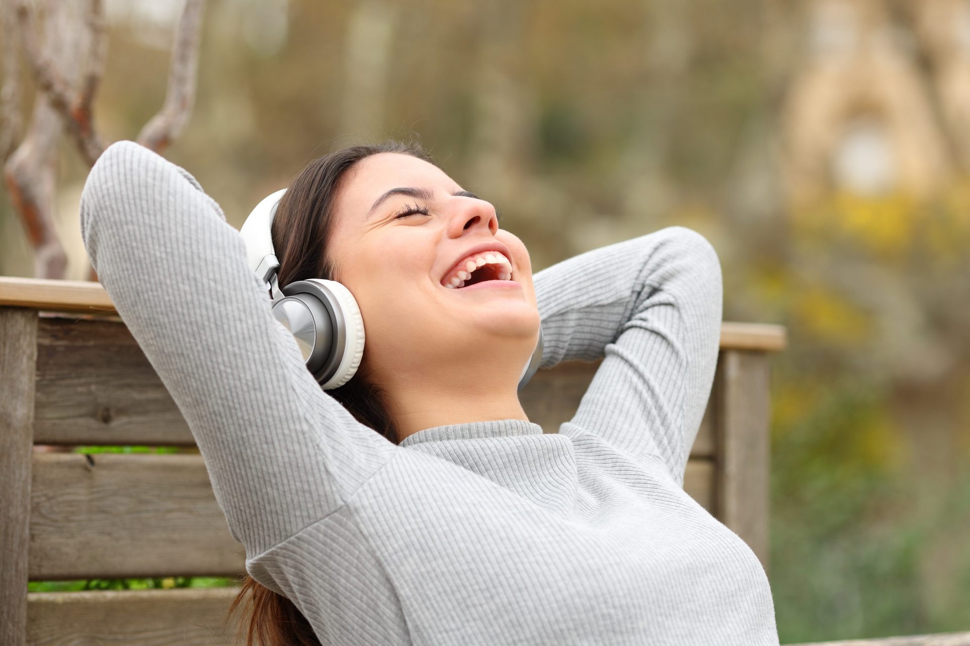 Young woman listening to comedy podcast laughing