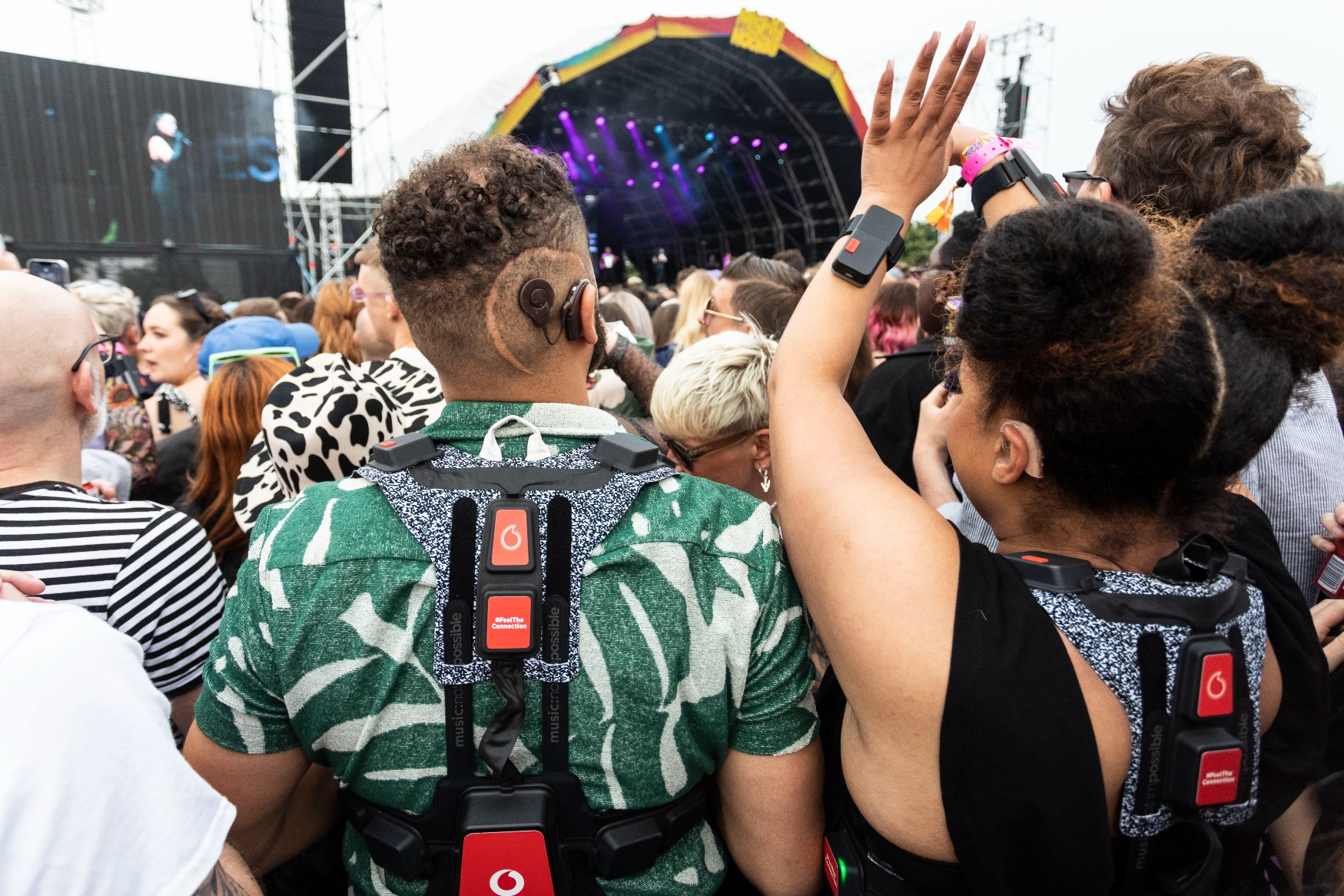 Rear view of festival goers wearing Vodafone 5G haptic suits at Mighty Hoopla.