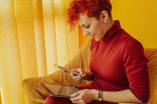 Women In Red Jumper On Smartphone And Tablet